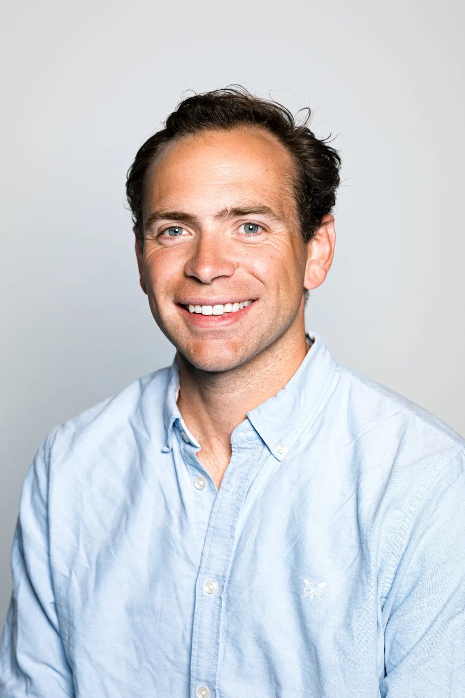 Classic corporate headshot on a neutral studio background